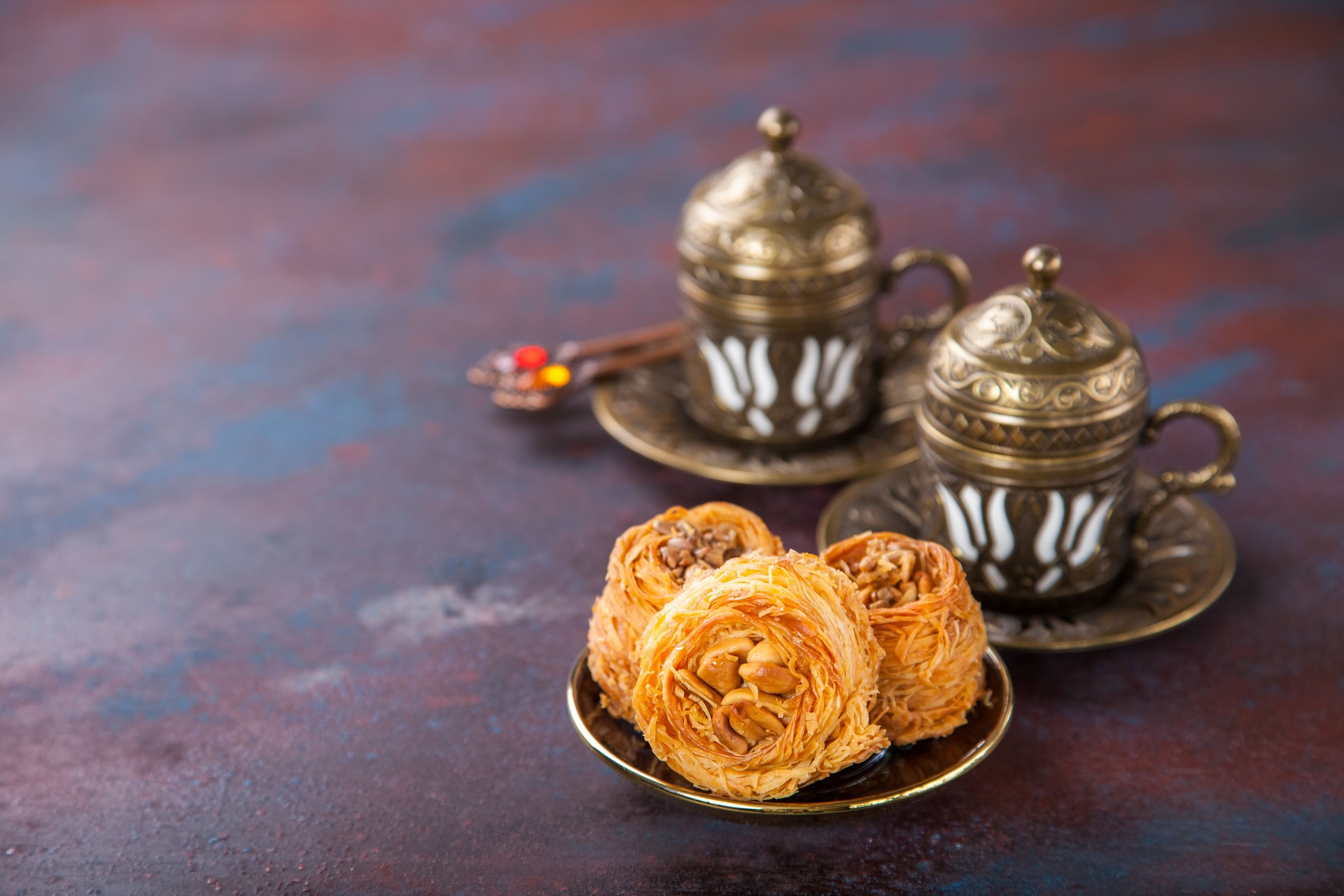 Traditional arabic dessert Kunafa with honey and nuts. Selective focus. Copy space.