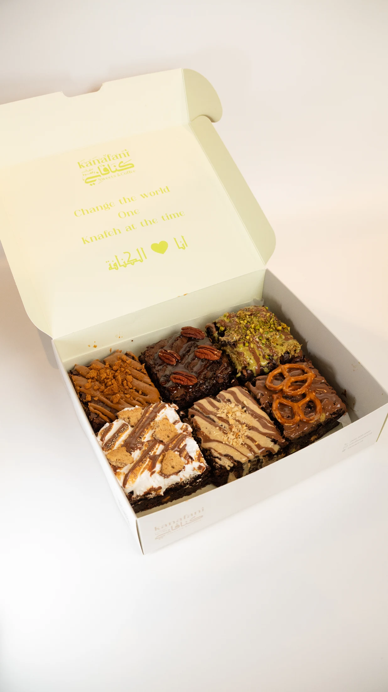 Six brownies in an open cream Kanafani box with the printed bilingual logo